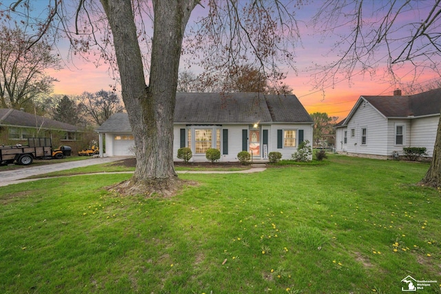 view of front of house with driveway and a yard