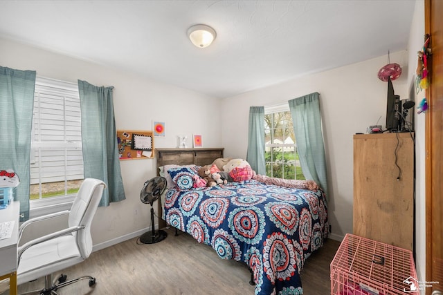 bedroom with wood finished floors and baseboards