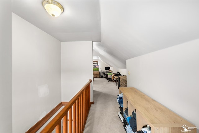 hallway with lofted ceiling and carpet