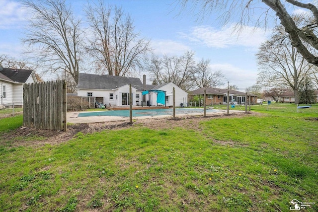 view of pool featuring fence, a covered pool, and a yard
