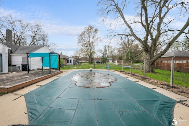 view of swimming pool featuring a fenced in pool, a lawn, fence, and a deck