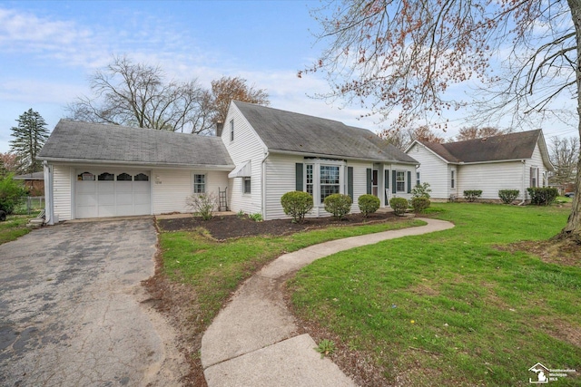 cape cod-style house with an attached garage, a shingled roof, a front lawn, and driveway