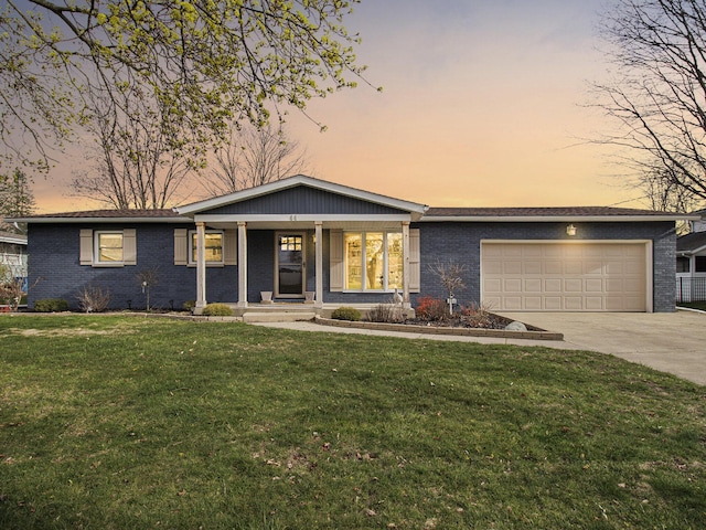 ranch-style house featuring an attached garage, a porch, a front lawn, and driveway