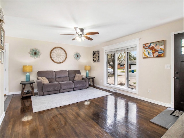living room with baseboards, a ceiling fan, wood finished floors, and visible vents