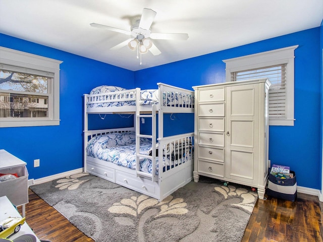 bedroom with ceiling fan, baseboards, and wood finished floors
