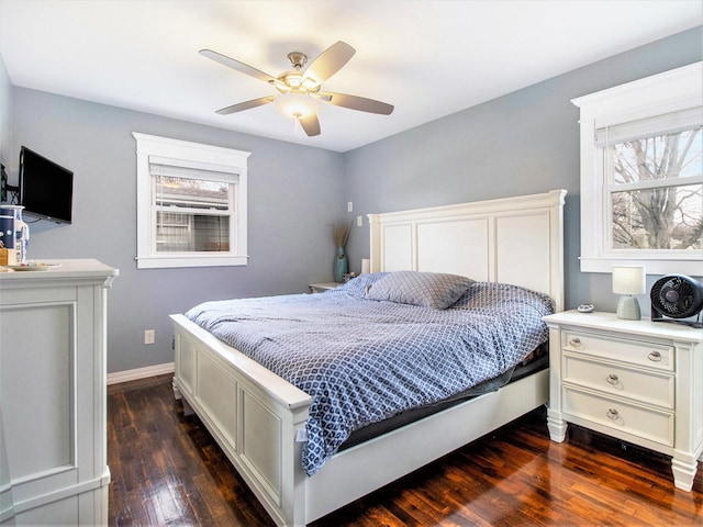 bedroom featuring multiple windows, ceiling fan, baseboards, and dark wood-style flooring