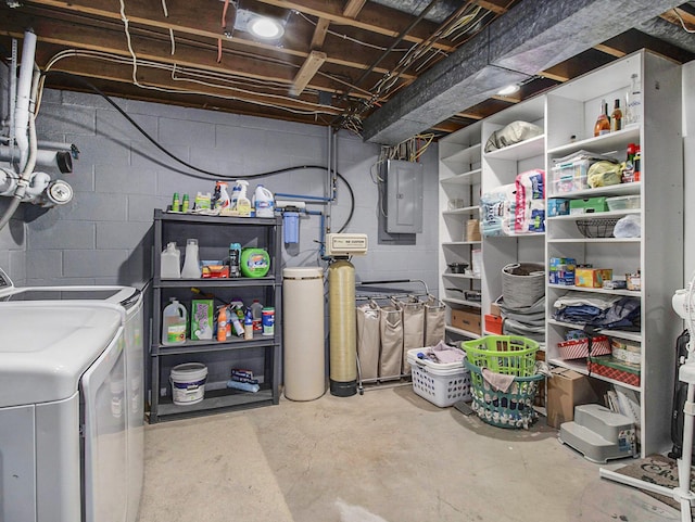 unfinished basement featuring electric panel, washer and dryer, and concrete block wall