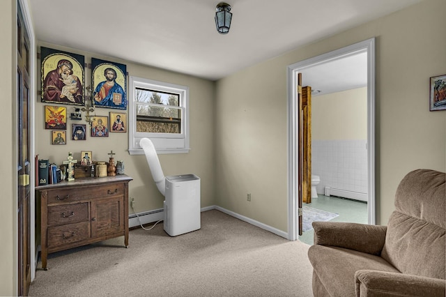 sitting room with a baseboard heating unit and light colored carpet