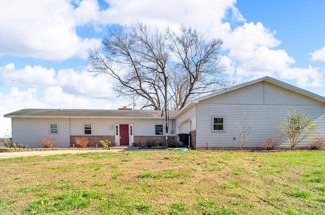 back of property with an attached garage and a yard