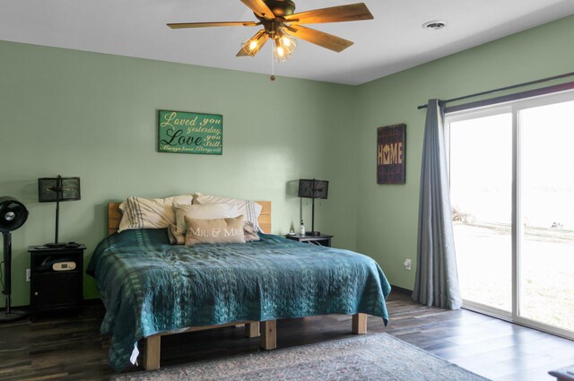 bedroom featuring wood finished floors, access to outside, and multiple windows