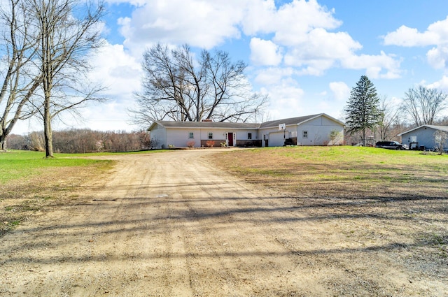 ranch-style house featuring dirt driveway and a chimney
