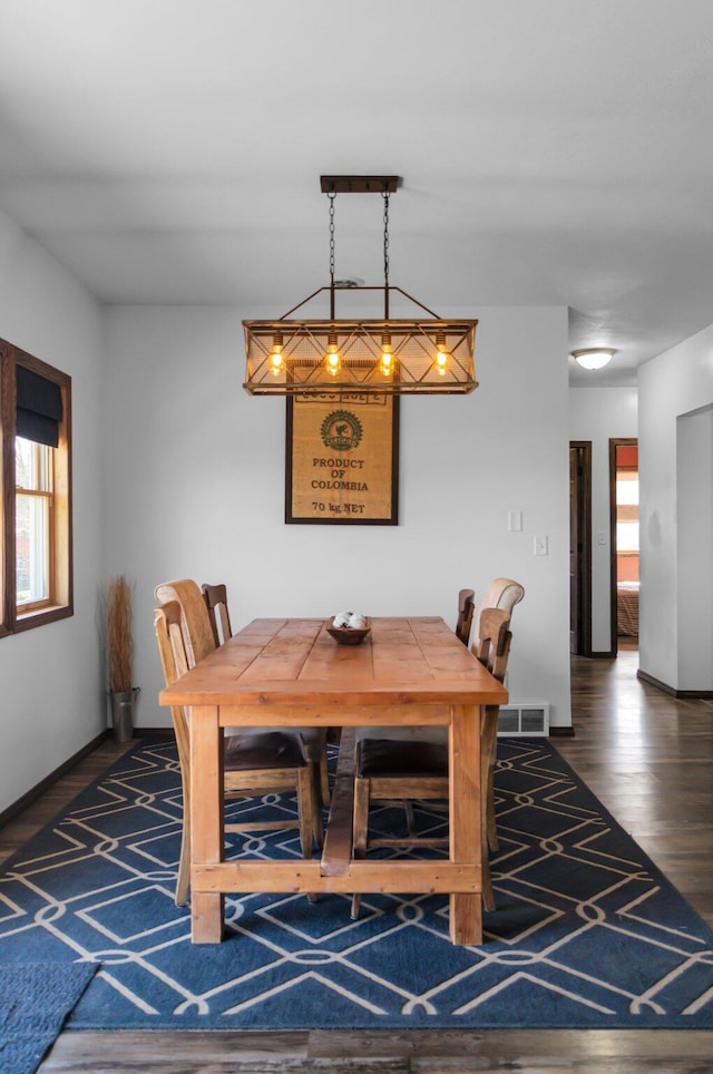 dining room with wood finished floors, visible vents, and baseboards