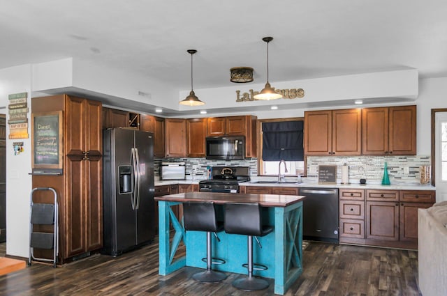 kitchen featuring a sink, tasteful backsplash, appliances with stainless steel finishes, and dark wood-style flooring