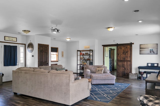 living area with a barn door, dark wood-style flooring, and recessed lighting
