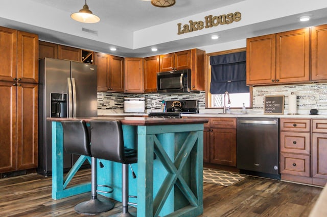 kitchen with dark wood finished floors, visible vents, decorative backsplash, and stainless steel appliances