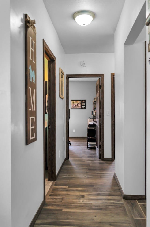 hall featuring wood finished floors and baseboards