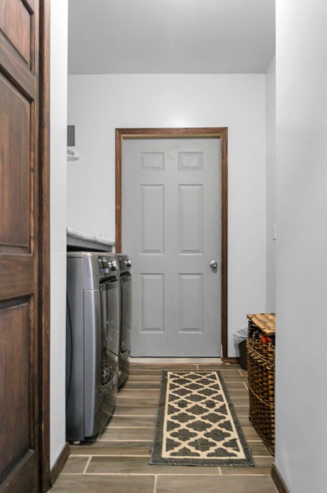 clothes washing area featuring wood finished floors, washer and clothes dryer, and laundry area