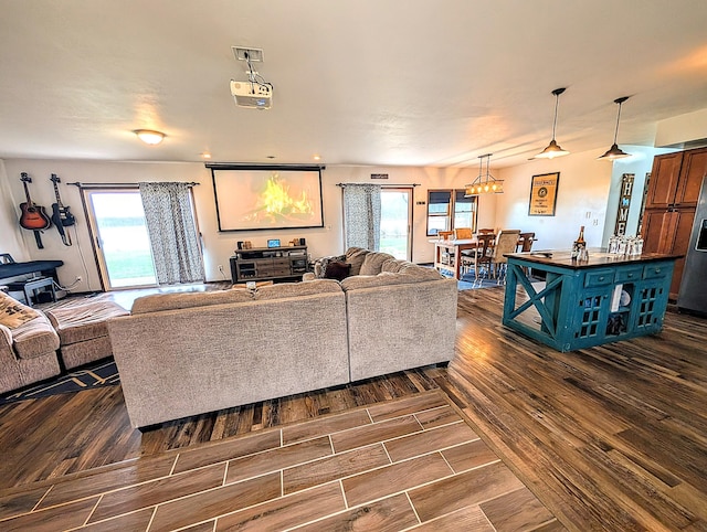 living area with a wealth of natural light and dark wood-type flooring
