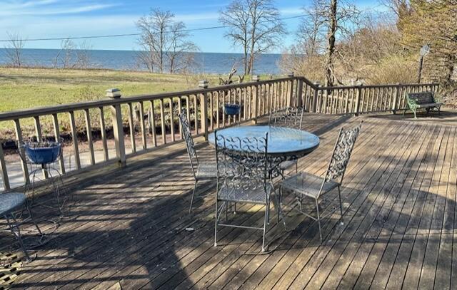 deck featuring outdoor dining space and a water view