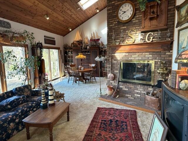 carpeted living area featuring a fireplace, wood ceiling, a skylight, and high vaulted ceiling