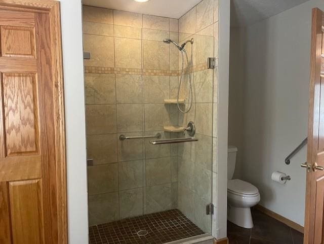 full bathroom with a shower stall, toilet, tile patterned floors, and baseboards