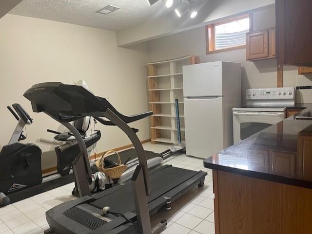 exercise area with visible vents and a textured ceiling