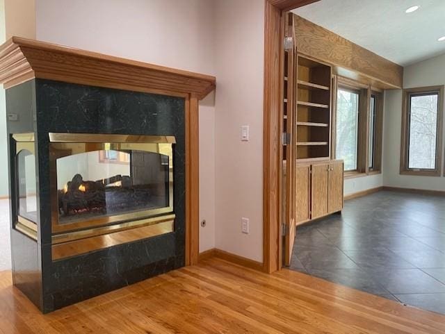 interior details with baseboards, wood finished floors, and a fireplace