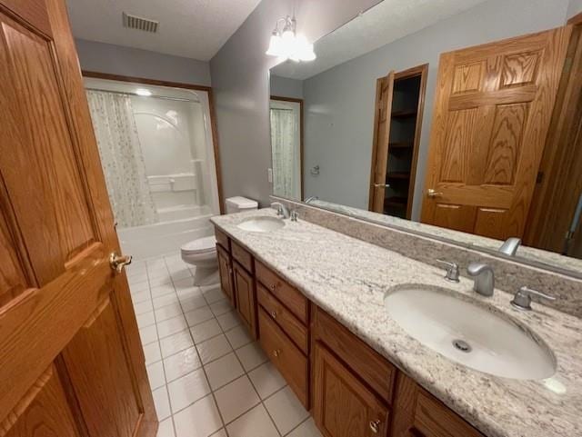 full bath featuring double vanity, tile patterned flooring, toilet, and a sink