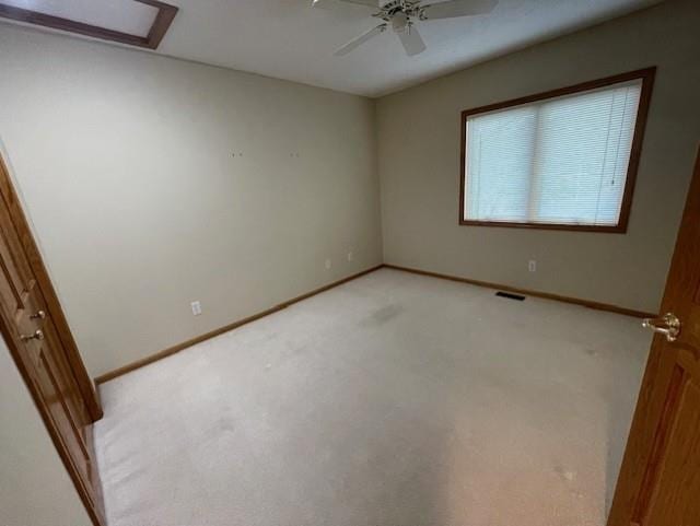 unfurnished room with light carpet, baseboards, visible vents, and a ceiling fan