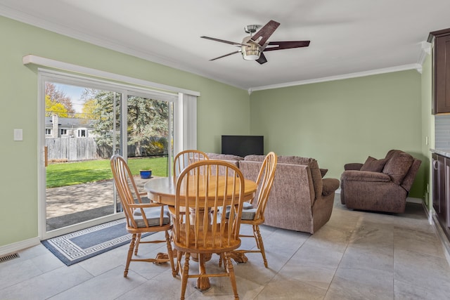 dining space with crown molding, a ceiling fan, baseboards, and visible vents
