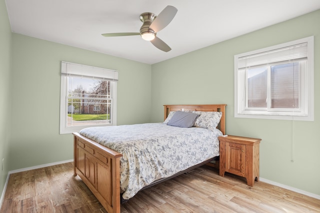 bedroom featuring baseboards, ceiling fan, and light wood-style flooring