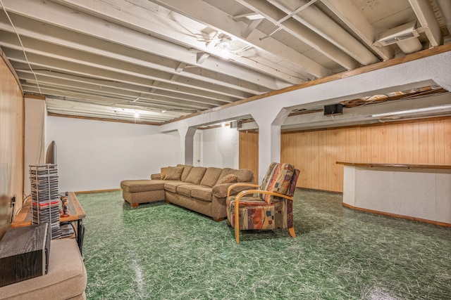 living room featuring wood walls and dark floors