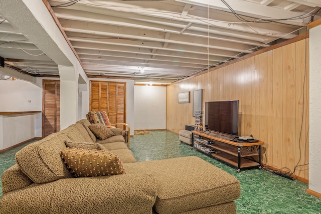 carpeted living area featuring wooden walls