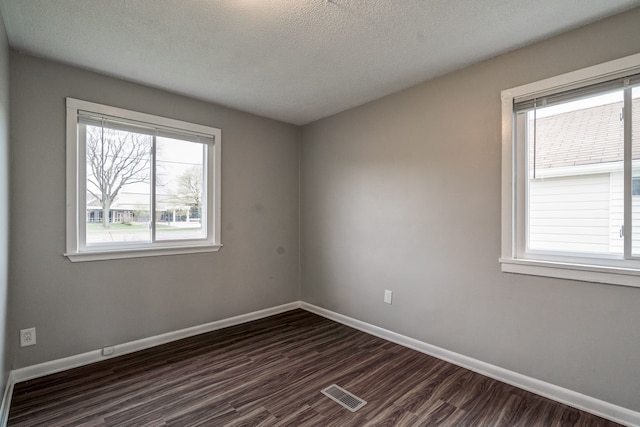 34038 Caseville Ct, Westland, MI 48186 - unfurnished room featuring a wealth of natural light, dark wood-type flooring, visible vents, and baseboards