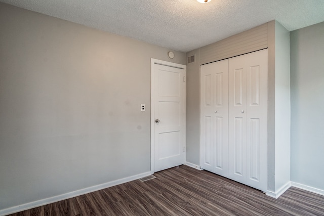 34038 Caseville Ct, Westland, MI 48186 - unfurnished bedroom featuring dark wood-style floors, a textured ceiling, visible vents, baseboards, and a closet
