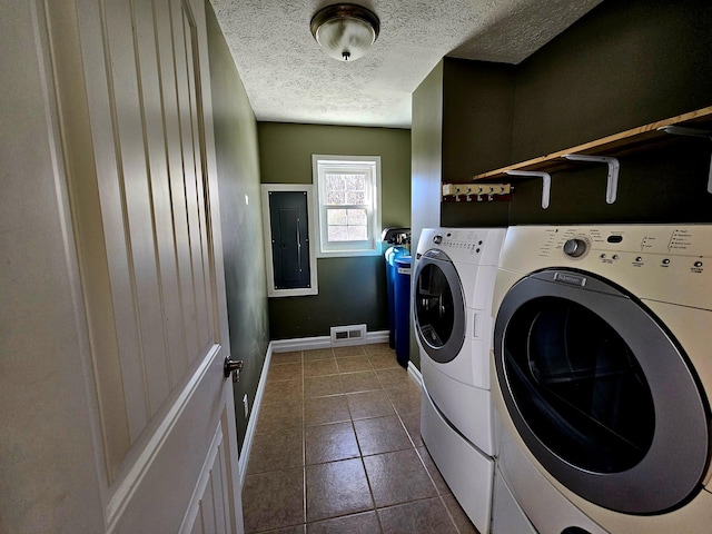 clothes washing area with laundry area, visible vents, independent washer and dryer, dark tile patterned floors, and a textured ceiling