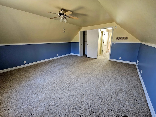 additional living space featuring lofted ceiling, carpet floors, a ceiling fan, and baseboards
