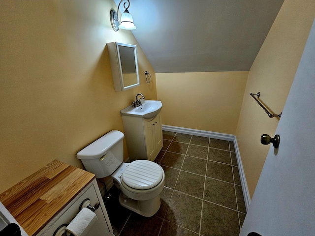 bathroom featuring tile patterned floors, vaulted ceiling, toilet, vanity, and baseboards