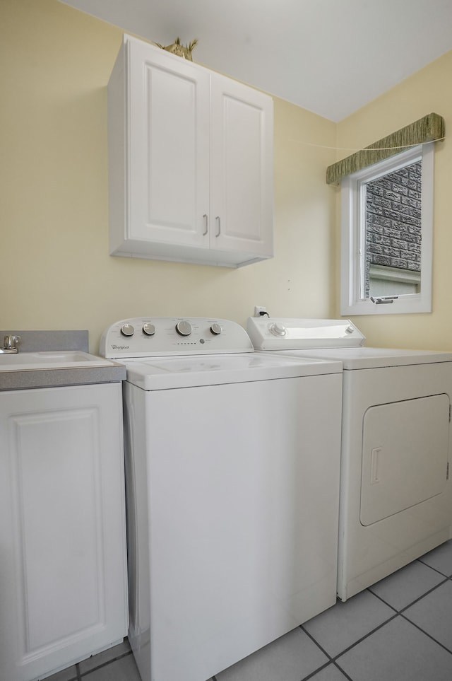 laundry room featuring light tile patterned floors, cabinet space, a sink, and independent washer and dryer