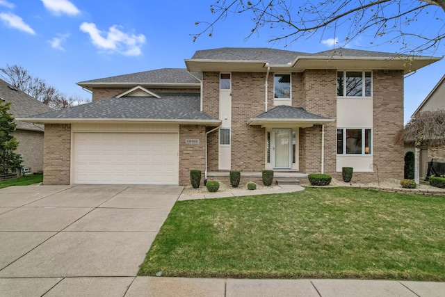 prairie-style house featuring roof with shingles, concrete driveway, a garage, brick siding, and a front yard