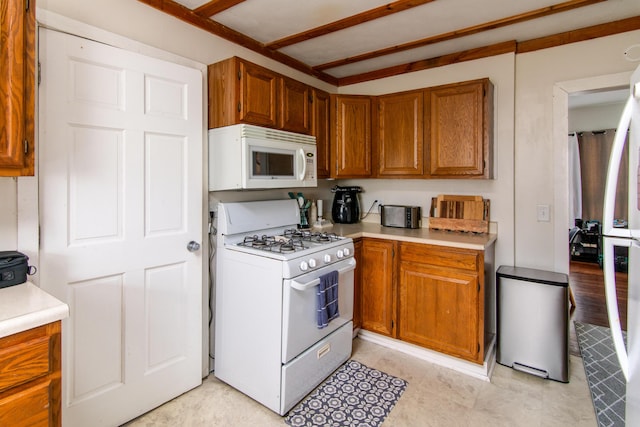 kitchen featuring brown cabinets, white appliances, and light countertops