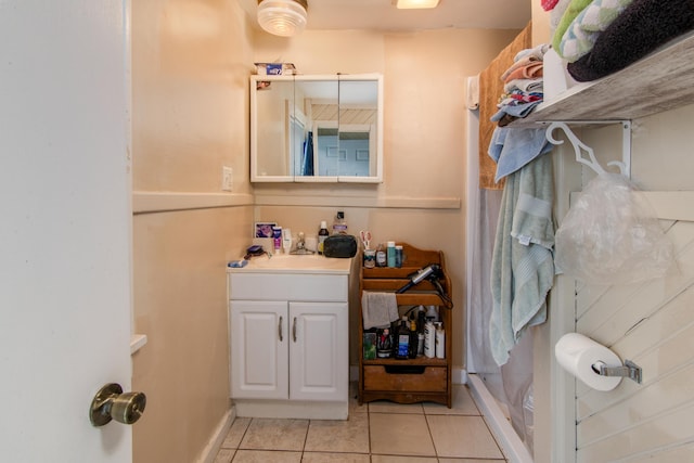 bathroom featuring tile patterned floors, walk in shower, vanity, and baseboards