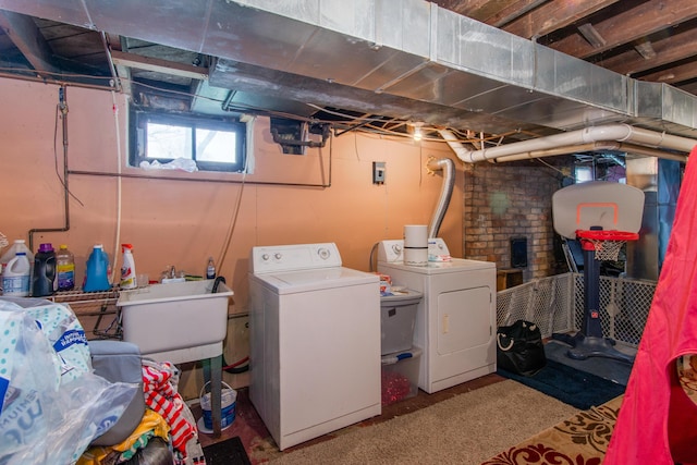 laundry room featuring washing machine and dryer, carpet flooring, a sink, and laundry area