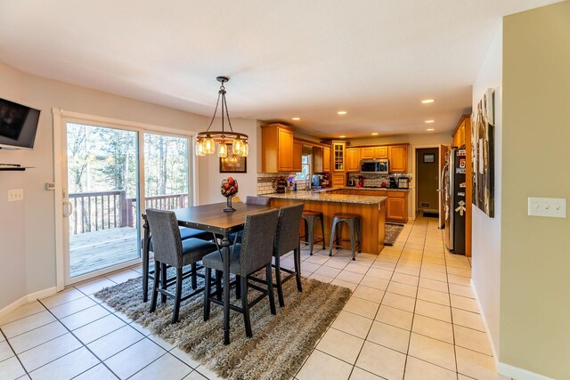 dining room featuring baseboards, light tile patterned flooring, a chandelier, and recessed lighting