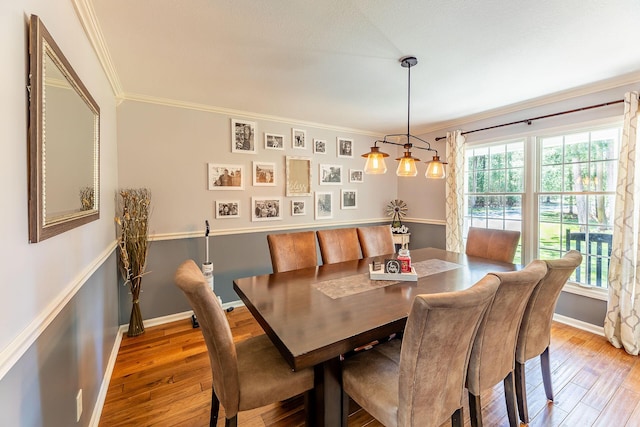 dining room featuring light wood-style flooring, baseboards, and ornamental molding