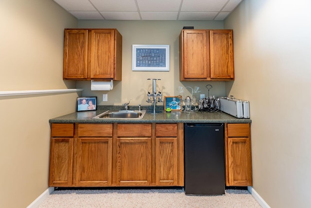 kitchen featuring dark countertops, a paneled ceiling, baseboards, and refrigerator