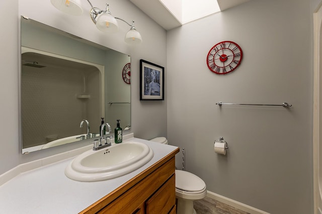 bathroom with baseboards, vanity, and toilet