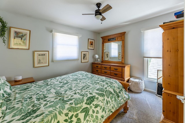 carpeted bedroom featuring ceiling fan, baseboards, and multiple windows