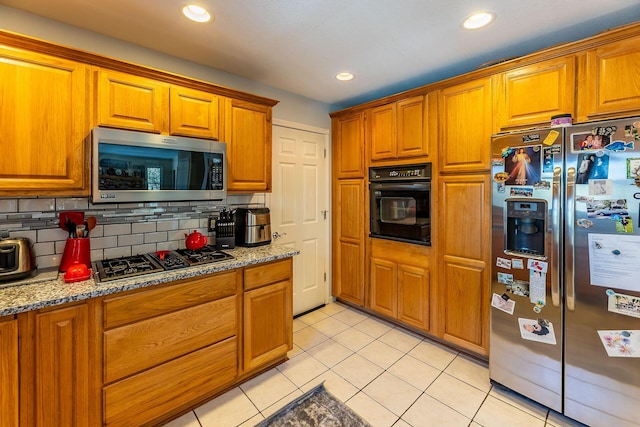 kitchen featuring brown cabinets, appliances with stainless steel finishes, and light tile patterned floors