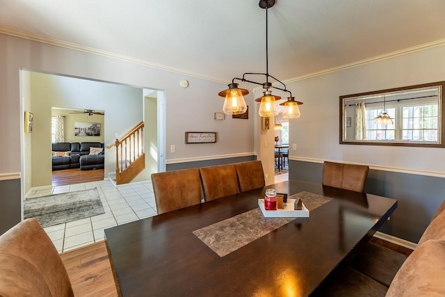 tiled dining room featuring baseboards, stairs, and crown molding